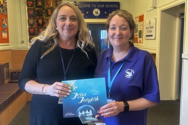 Emma King presenting a copy of Jessie the Jellyfish to Joanne Hutton from Cestria Primary School.